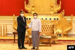 រូប​ឯកសារ៖ លោក ប្រាក់ សុខុន (ឆ្វេង) រដ្ឋមន្ត្រី​ការបរទេស​កម្ពុជា និង​ជា​ប្រេសិតរបស់​ប្រធាន​អាស៊ាន ចាប់​ដៃ​គ្នា​ជាមួយ​នឹង​ប្រមុខ​រដ្ឋាភិបាល​យោធា​មីយ៉ាន់ម៉ា លោក​ឧត្តមសេនីយ៍ Min Aung Hlaing ទីក្រុង​ណៃពិដោ ប្រទេស​មីយ៉ាន់ម៉ា ថ្ងៃទី២១ ខែមីនា ឆ្នាំ២០២២។ (AFP PHOTO / MYANMAR MILITARY INFORMATION TEAM)