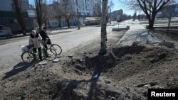 Civili pored kratera u Lugansku, 30. mart 2022.