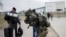 A man carries combat gear as he leaves Poland to fight in Ukraine, at the border crossing in Medyka, Poland, Wednesday, March 2, 2022. (AP Photo/Markus Schreiber, File)