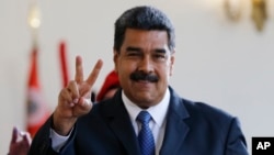 Venezuela's President Nicolas Maduro makes the victory sign after a meeting with former Spanish Prime Minister Jose Luis Rodriguez Zapatero at the presidential palace in Caracas, Venezuela, May 18, 2018. Maduro is seeking a new six-year mandate and, despite crippling hyperinflation and widespread shortages of food and medicine, he is widely expected to win it Sunday.