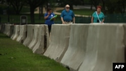 Barricades are seen as tourists pass by at the west front of the U.S. Capitol in Washington, D.C., where security has been increased for the upcoming July 4 holiday, July 2, 2015.