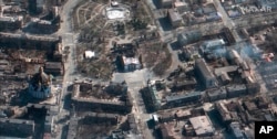 This satellite photo provided by Maxar Technologies March 19, 2022, shows the aftermath of an airstrike earlier in the week on the Mariupol Drama Theater, in Mariupol, Ukraine, and the area around it.