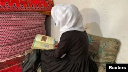 یک دختر افغان حین درس خواندن در خانه اش