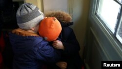 Los niños refugiados ucranianos se abrazan mientras descansan en la taquilla de la estación de tren Przemysl Glowny, después de huir de la invasión rusa de Ucrania, en Przemysl, Polonia, el 24 de marzo de 2022.