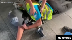 印尼女記者英達(Veby Indah)被橡皮子彈打中右眼倒地瞬間。 （美國之音電視畫面視頻截圖）