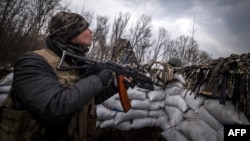 រូបឯកសារ៖ ទាហាន​អ៊ុយក្រែន​ម្នាក់ កាន់​កាំភ្លើង ហើយ​មើល​យន្តហោះ​គ្មាន​មនុស្ស​បើក (drone) របស់​រុស្ស៊ី​នៅ​ក្នុង​លេណដ្ឋាន​មួយ​នៅ​ភាគ​ខាង​កើត​ក្រុង Kharkiv ប្រទេស​អ៊ុយក្រែន កាលពី​ថ្ងៃទី៣១ ខែមីនា ឆ្នាំ២០២២។