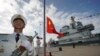 Pengibaran bendera nasional China saat upacara peresmian kapal induk Shandong China di Sanya. Kementerian Luar Negeri China, Rabu (21/9), memperingatkan bahwa kerja sama pertahanan di antara negara-negara "tidak boleh diarahkan ke pihak ketiga." (Foto: Xinhua via AP)