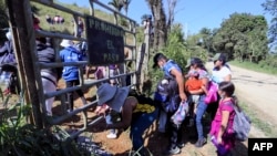 Migrantes que quieren llegar a EE. UU., en su mayoría hondureños y nicaragüenses, cruzan de Honduras a Guatemala a través de un sendero ilegal, en Corinto, Honduras, el 15 de enero de 2022.