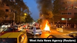 FILE - A police motorcycle burns during a protest over the death of Mahsa Amini, a woman who died after being arrested by the Islamic republic's "morality police", in Tehran, Iran, Sept. 19, 2022. ran's hardline judiciary has indicted 11 people over the k