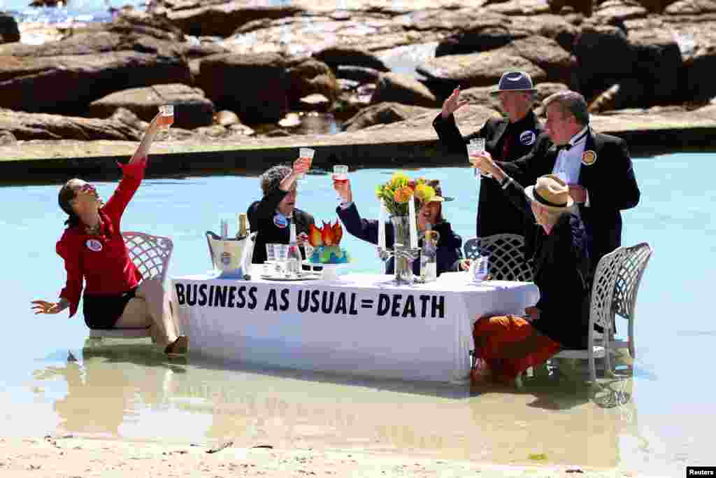 Climate activists from Extinction Rebellion stage a street theatre on a beach during COP27 Water Day, to highlight the fact that fossil fuel "Business as Usual" is leading to climate disasters, such as sea level rise, in Cape Town, South Africa.