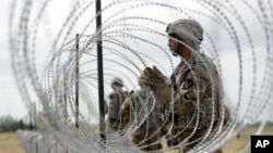 Members of a U.S Army engineering brigade place Concertina wire around an encampment for troops, Department of Defense and U.S. Customs and Border Protection near the U.S.-Mexico International bridge, Nov. 4, 2018, in Donna, Texas.