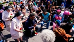 Sejumlah warga tampak berdoa di luar swalayan Tops yang menjadi lokasi penembakan di Buffalo, New York, pada 15 Mei 2022. (Foto: AP/Matt Rourke)