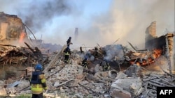 Cette photographie publiée par les services d'urgence de l'État ukrainien le 8 mai 2022 montre des pompiers ukrainiens éteignant un incendie après que des missiles russes ont touché une école à Bilohorivka, le 7 mai 2022. (Photo AFP / Service d'urgence de l'État ukrainien)