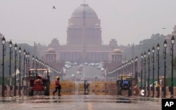 FILE - A construction worker walks across a road during a heat wave, in New Delhi, May 2, 2022. (AP Photo/Manish Swarup)