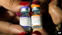 FILE - A nurse holds a vial of the Pfizer COVID-19 vaccine for children ages 5 to 11, right, and a vial of the vaccine for adults, which has a different colored label, at a vaccination station in Jackson, Miss., Tuesday, Feb. 8, 2022. (AP Photo/Rogelio V. Solis, File)