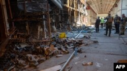 Ukrajinski policajci vrše utvrđivanje stepena razaranja jedne od najveće pijace garderobe "Barabašovo" (na više od 75 hetara), u Harkovu, 16. maja 2022., koja je uništena u bombardovanju tokom ruske invazije na Ukrajinu.