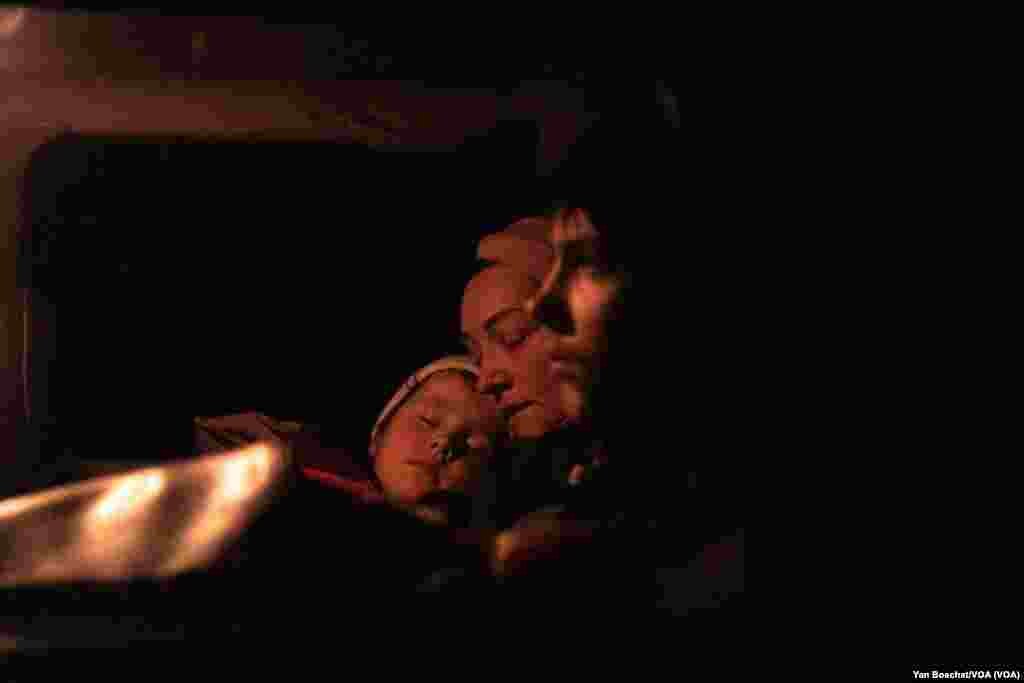 A family rests after travelling for hours from a small city near Mariupol, in a refugee center in Zaporizhzhia, May 4, 2022. (Yan Boechat/VOA) 