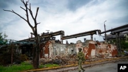A Russian soldier patrols a destroyed part of the Illich Iron & Steel Works Metallurgical Plant in Mariupol, in territory under the government of the Donetsk People's Republic, eastern Ukraine, May 18, 2022.