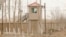 FILE - A security person watches from a guard tower around a detention facility in Yarkent County in northwestern China's Xinjiang Uyghur Autonomous Region on March 21, 2021.