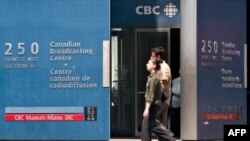 FILE - Pedestrians walk in front of the Canadian Broadcasting Corporation (CBC) building in downtown Toronto, Canada, June 7, 2006. 
