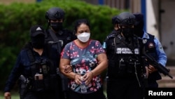 Oficiales de policía escoltan a la líder del cartel de drogas Herlinda Bobadilla luego de una solicitud de extradición para ella y sus hijos por parte de Estados Unidos, en Tegucigalpa, Honduras, 15 de mayo de 2022. REUTERS