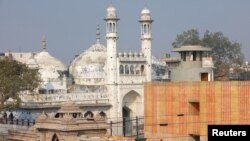 FILE - A worker stands on a temple rooftop adjacent to the Gyanvapi Mosque in the northern city of Varanasi, India, December 12, 2021. (REUTERS/Pawan Kumar/File Photo)