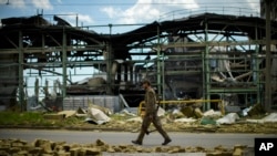A Ukrainian serviceman walks past a gypsum manufacturing plant destroyed in a Russian bombing in Bakhmut in eastern Ukraine, May 28, 2022.
