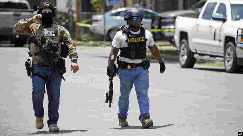 Police walk near Robb Elementary School following a shooting, May 24, 2022, in Uvalde, Texas.
