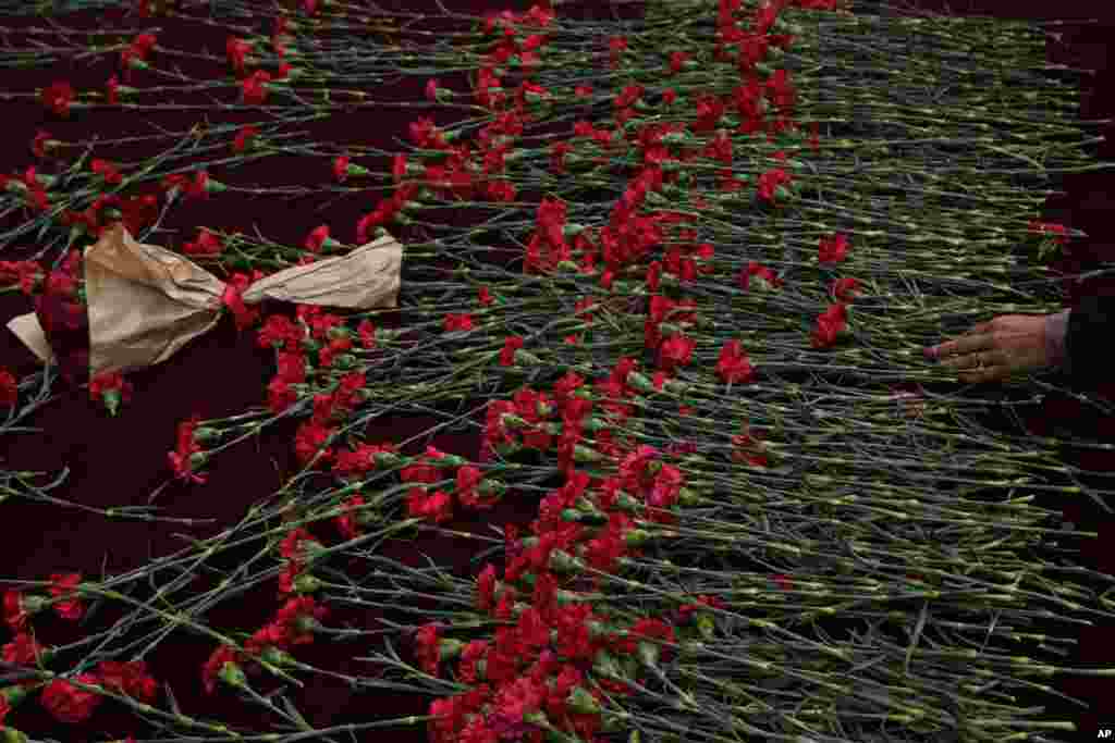 People put flowers over a memorial placed on the spot of Sunday's explosion on Istanbul's popular pedestrian Istiklal Avenue, Turkey.