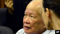 នៅ​ក្នុង​រូបថត​ដែល​ចេញ​អង្គ​ជំនុំ​ជម្រះ​វិសាមញ្ញ​ក្នុង​តុលា​ការ​កម្ពុជា​នេះ បង្ហាញ ខៀវ សំផន (ឆ្វេង) អតីត​មេដឹកនាំ​ខ្មែរ​ក្រហម អង្គុយ​ស្តាប់​សវនាការ​នៅ​ក្នុង​បន្ទប់​តុលាការ​ដែល​គាំទ្រ​ដោយ​អង្គការ​សហ​ប្រជាជាតិ ក្នុង​រាជធានី​ភ្នំពេញ​នៅ​ថ្ងៃ​ទី១៧ ខែតុលា ឆ្នាំ២០១៤។