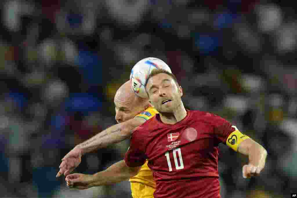 Denmark's Christian Eriksen, foreground, and Australia's Aaron Mooy jump for the ball during the World Cup group D soccer match between Australia and Denmark, at the Al Janoub Stadium in Al Wakrah, Qatar.