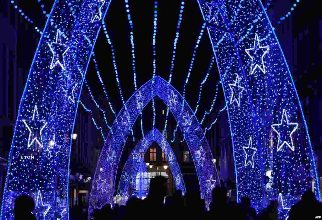 People walk past a Christmas lights on South Molton street in central London, Dec. 3, 2022.