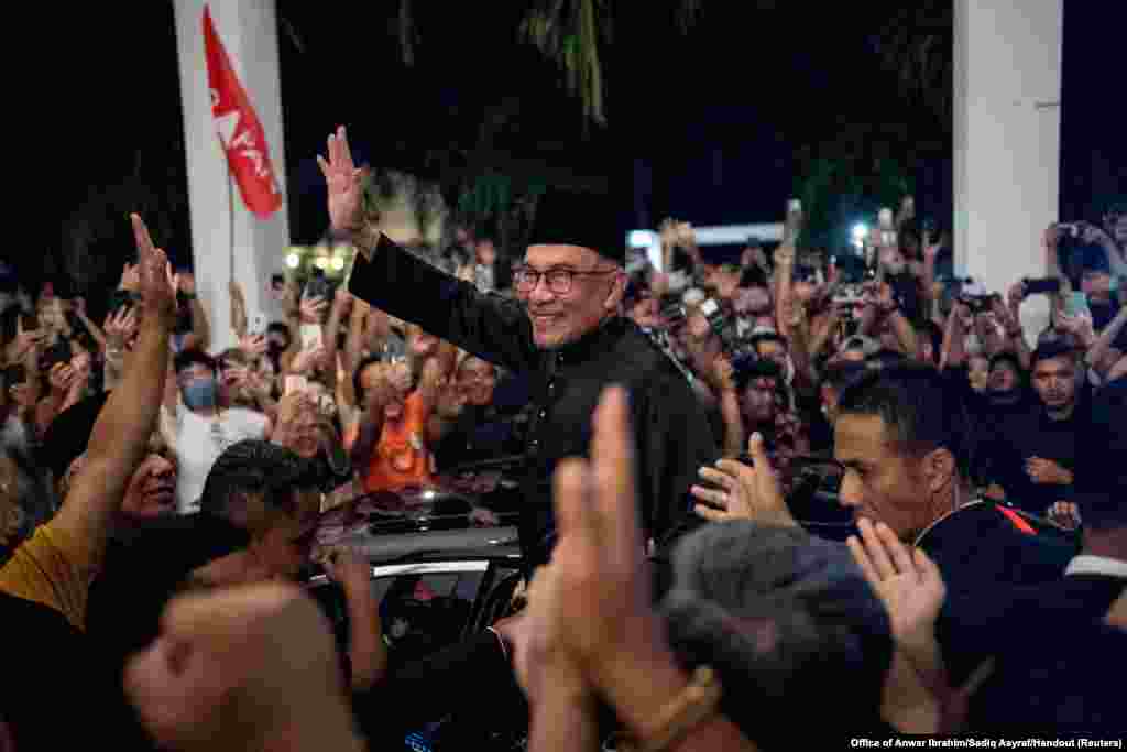 Malaysia's newly appointed Prime Minister Anwar Ibrahim waves to his supporters after his news conference in Sungai Long, Selangor.