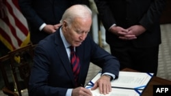 President Joe Biden signs a resolution to avert a nationwide rail shutdown, in the Roosevelt Room of the White House in Washington, DC, on Dec. 2, 2022. 