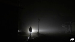 ស្ត្រី​មា្នក់​ដើរ​កាត់​តំបន់​កណ្តាល​ក្រុង​កៀវ ដែល​ដាច់​ចរន្ត​អគ្គិសនី​ក្រោយ​ពី​ត្រូវ​រង​ការ​វាយប្រហារ​រ៉ុក្កែត​រុស្ស៊ី កាល​ពី​ថ្ងៃ​ទី​២៤ ខែ​វិច្ឆិកា ឆ្នាំ​២០២២។