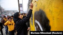 Seorang aktivis sosial Afghanistan dan anggota LSM Peace Street melukis grafiti di dinding Gedung Kementerian p=Pendidikan di Kabul. (Foto: Reuters/Morteza Nikoubazl)