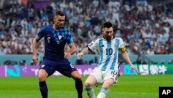 Argentina's Lionel Messi and Croatia's Dejan Lovren focus on the ball during the World Cup semifinal soccer match between Argentina and Croatia at the Lusail Stadium in Lusail, Qatar, Dec. 13, 2022. Messi is striving to win in Sunday's final the one major title that has eluded him.