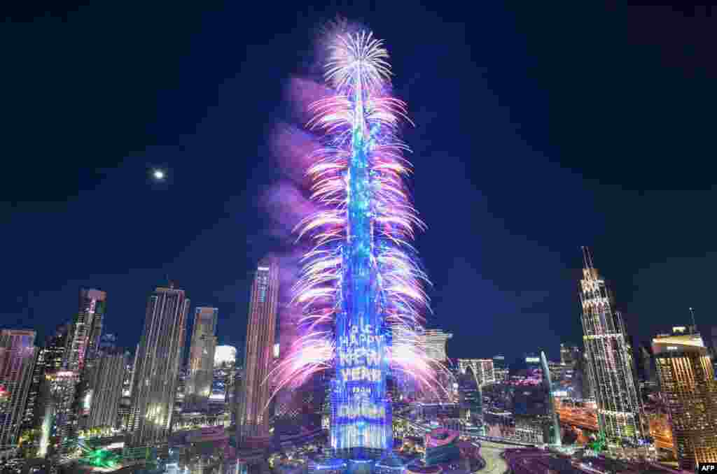 Los fuegos artificiales de Nochevieja iluminan la emblemática torre Burj Khalifa a la medianoche en el emirato del Golfo de Dubai el 31 de diciembre de 2022. [AFP]