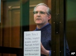 FILE - Paul Whelan, a former U.S. marine who was arrested for alleged spying, listens to the verdict in a courtroom at the Moscow City Court in Moscow, Russia, June 15, 2020.