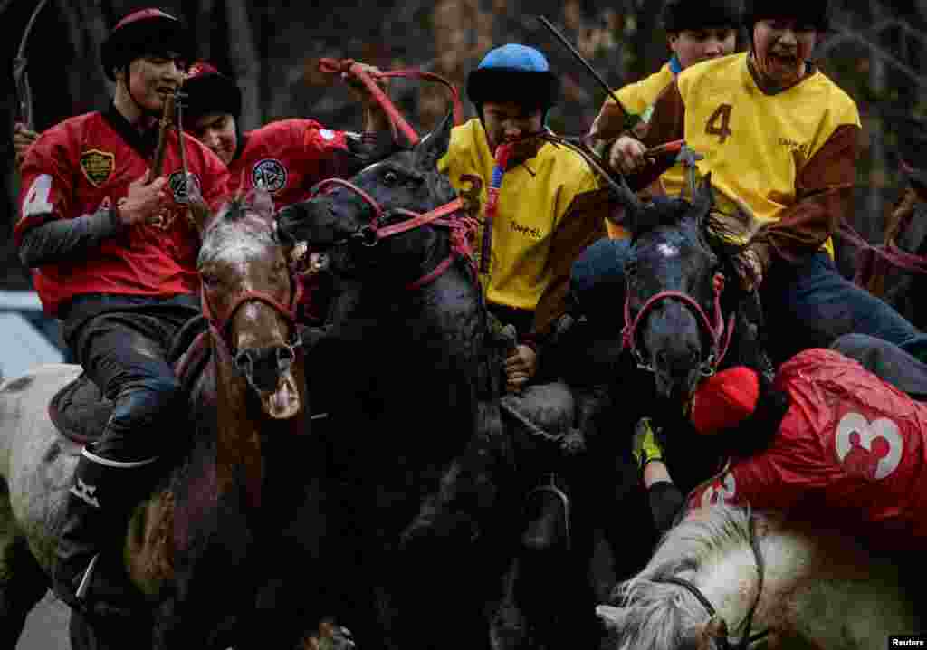 Horsemen play Kokpar, a traditional game between two teams competing to throw a dummy of a goat into a scoring circle, during the championship in Almaty, Kazakhstan, Nov. 5, 2022.