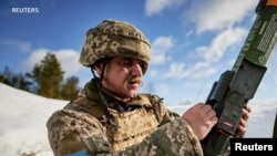 Mwanajeshi wa Ukraine akitumia silaha wakati wa mazoezi ya kijeshi huko mkoa wa Lviv. 