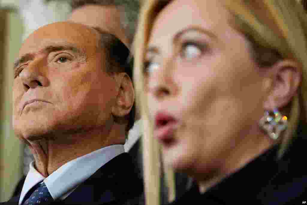 Forza Italia leader Silvio Berlusconi, left, listens to Brothers of Italy's leader Giorgia Meloni talking to journalists at the Quirinale Presidential Palace after a meeting with Italian President Sergio Mattarella as part of a round of consultations with party leaders to try and form a new government, in Rome.