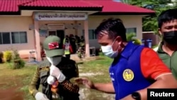 រូបភាព​ពី​វីដេអូ​កាល​ពី​ថ្ងៃ​ទី​៦ ខែ​តុលា ឆ្នាំ​២០២២ នេះ បង្ហាញ​មន្ត្រី​និង​អាជ្ញាធរ​យាម​នៅ​ច្រកចូល​នៃ​មជ្ឈមណ្ឌល​មើលថែ​កុមារ​នេះ​នៅ​ក្នុង​ក្រុង Uthai Sawan ខេត្ត Nong Bua Lamphu នា​ភាគ​ឦសាន​ប្រទេស​ថៃ។ (TPBS/Reuters via Reuters)