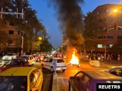 FILE - Waandamanaji wakichoma pikipiki ya polisi wa maadili mjini Tehran, Iran Septemba 19, 2022.