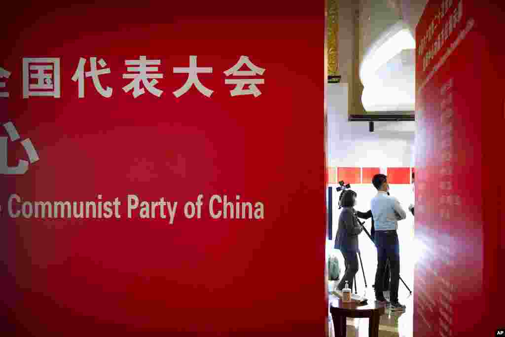 People stand in the lobby of a hotel for journalists covering the 20th National Congress of China's ruling Communist Party in Beijing. Chinese President Xi Jinping is widely expected to be conferred a third five-year term in office during the congress, which begins Sunday.