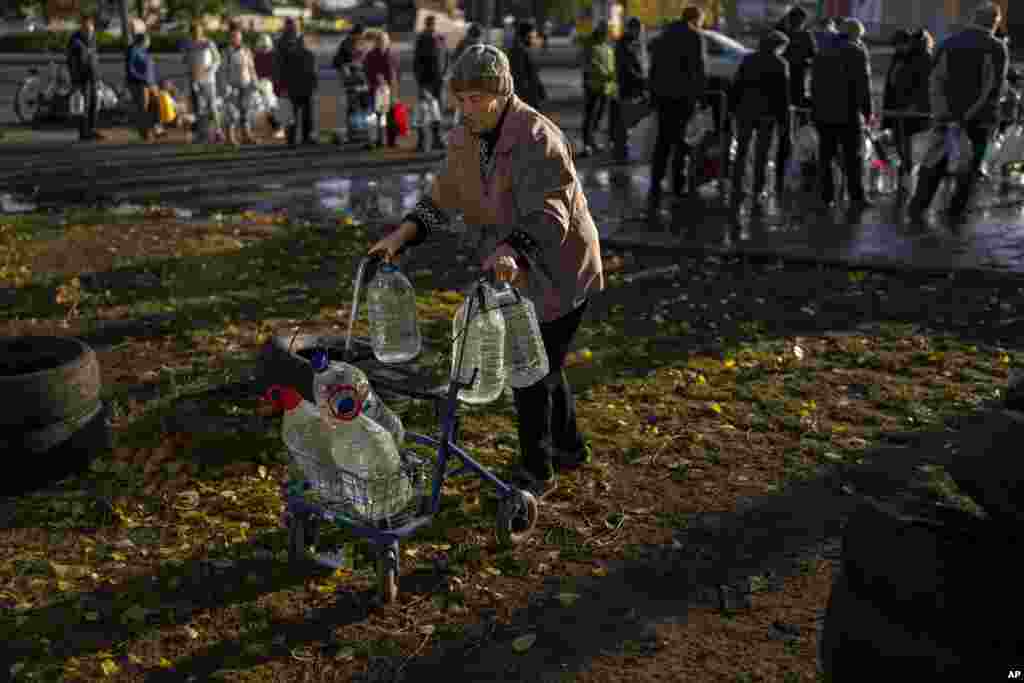 Catherine, 75, pushes her walker loaded with water bottles in the center of Mykolaiv, Ukraine.