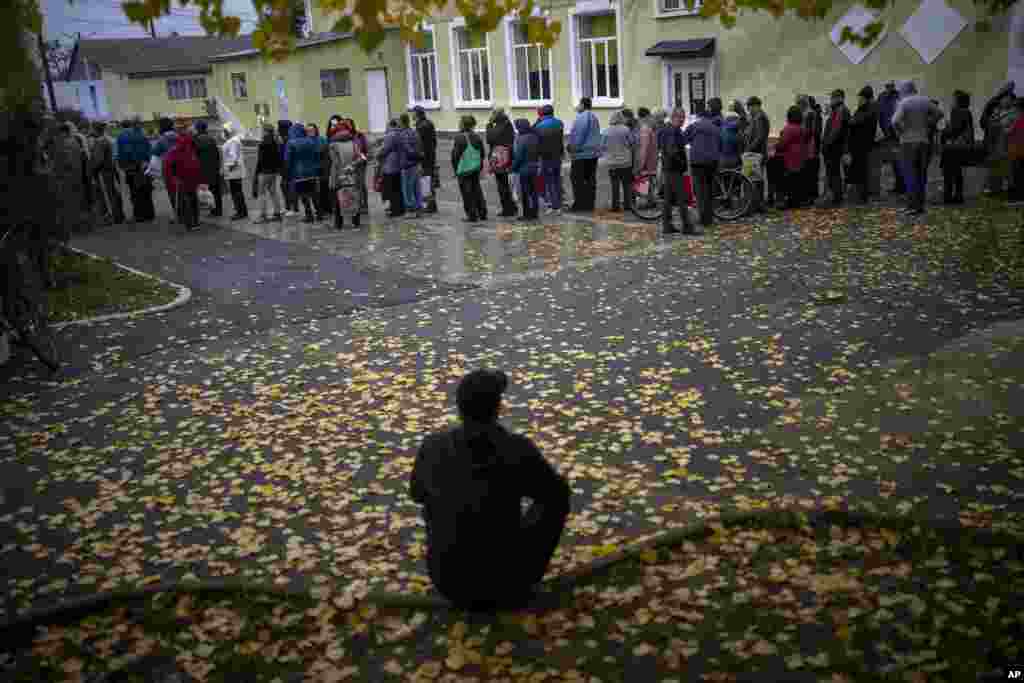 People queue to receive a daily ration of bread in a school in Mykolaiv, Ukraine.&nbsp;One person is allowed to receive free bread just once in three days.&nbsp;