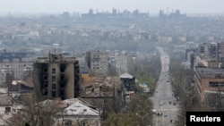 FILE - FILE PHOTO: Mandhari ya majengo yaliyoharibiwa na nyuma yake ni kiwanda cha chuma cha Azovstal upande wa kusini ya mji wa bandari wa Mariupol, Apr. 19, 2022.