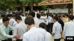 បេក្ខជន​ប្រឡង​ឈរ​តំរង់​ជួរ​មុខ​មណ្ឌល​ប្រឡង​ដើម្បី​ធ្វើ​ការ​ឆែក​រក​សំណើរ​ឯកសារ​មុន​ចូល​មណ្ឌល​ប្រឡង។ នៅ​រាជធានី​ភ្នំពេញ​ ថ្ងៃ​ចន្ទ ទី​២០ ខែ​សីហា ឆ្នាំ​២០១៨។ (ទី អូលីស្សា/VOA)