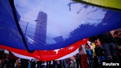 Supporters rallying for the nation’s new peace agreement with FARC hold a giant flag during a march in Bogota, Colombia, Nov. 15, 2016. The accord is expected to be signed Nov. 24, 2016.
